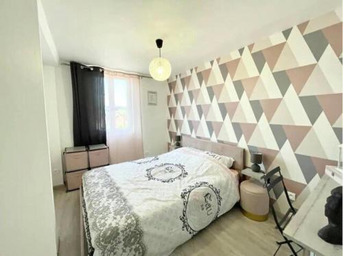 - une chambre avec un lit et un mur géométrique dans l'établissement Le Cottage Family, à Rouen