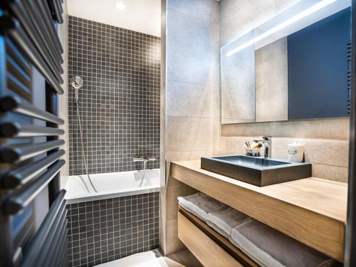 a bathroom with a sink and a bath tub at Appartement Tignes, 3 pièces, 5 personnes - FR-1-480-84 in Tignes
