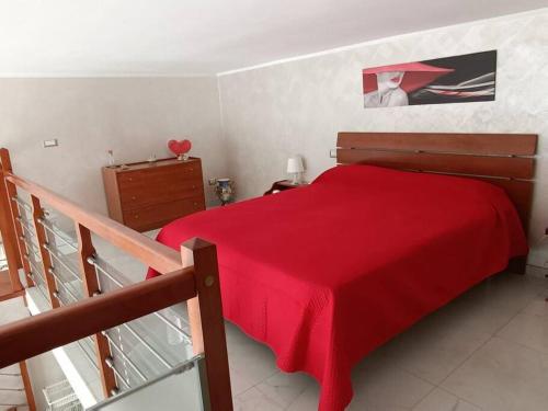 ein rotes Bett mit einer roten Decke in einem Schlafzimmer in der Unterkunft Casa Vacanza Raggio di sole in Giovinazzo