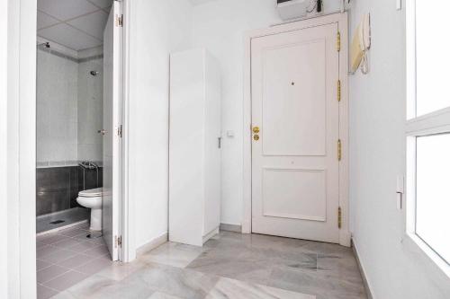łazienka z toaletą i białymi drzwiami w obiekcie COMFY AWAY - Apartamento Deluxe Centro Histórico w Sewilli