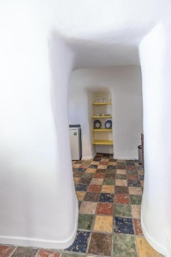 a room with a white wall and a checkered floor at Dreams Luxury Suites in Imerovigli