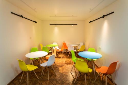 a room with tables and colorful chairs at La Casa EmilioAngi in Yerevan