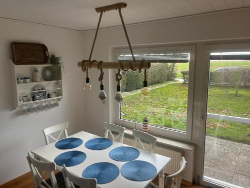 ein Esszimmer mit einem blauen und weißen Tisch und einem Fenster in der Unterkunft Kleine Scholle in Neuharlingersiel