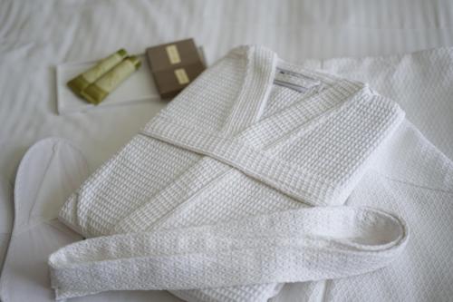 two white towels on a bed next to a brown object at Fthia Hotel in Lamía