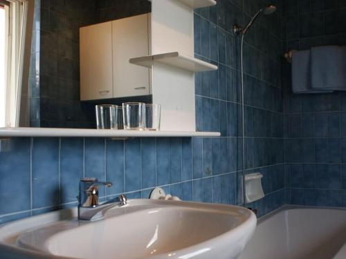La salle de bains est pourvue d'un lavabo, d'un miroir et d'une baignoire. dans l'établissement Belvilla, à Tirolo