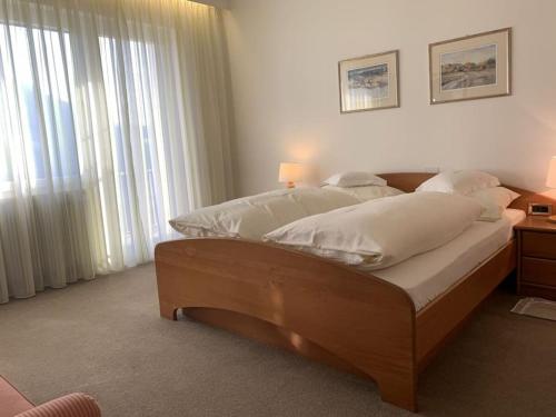 una camera da letto con un grande letto con cuscini bianchi di Belvilla a Tirolo