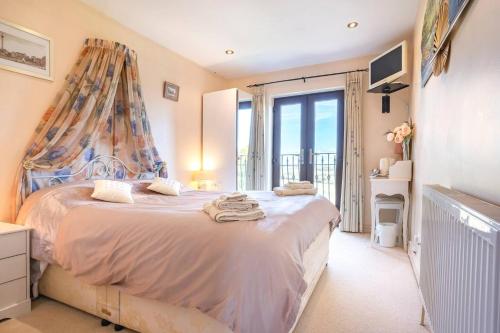a bedroom with a large bed and a balcony at Willow Ridge - a large country house with a king and Single or Twin room in Clutton