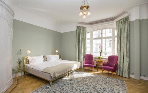 a bedroom with a bed and two purple chairs at Hotel Esplanade, BW Signature Collection in Stockholm