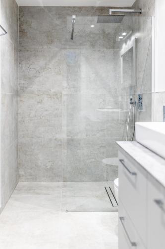 a bathroom with a glass shower with a sink at Baza Tlen in Zachełmie