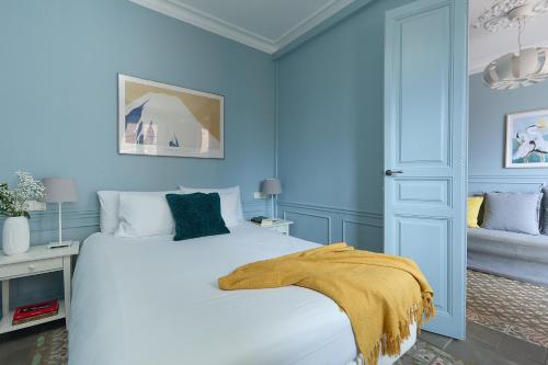 ein blaues Schlafzimmer mit einem Bett mit einer gelben Decke darauf in der Unterkunft Casa Cosi - El Farro 1 in Barcelona