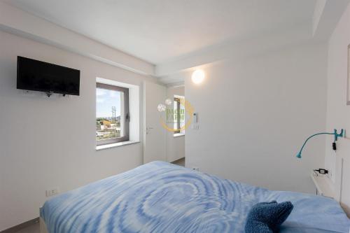 um quarto com uma cama e uma televisão na parede em Appartamento Luly Dachi Farm em Marina dʼAndora