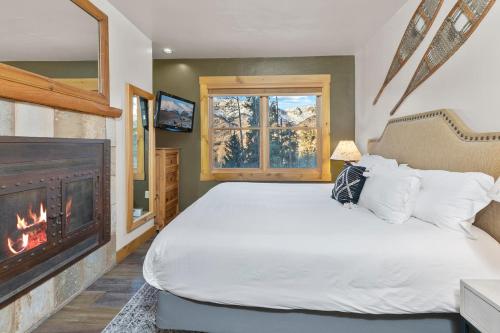 a bedroom with a bed and a fireplace at Have It All Ski in out Affordable Too in Telluride