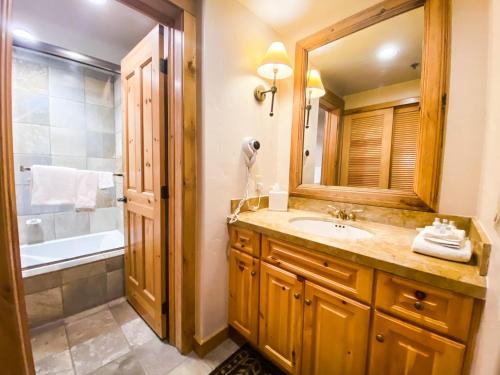 a bathroom with a sink and a mirror and a tub at Have It All Ski in out Affordable Too in Telluride