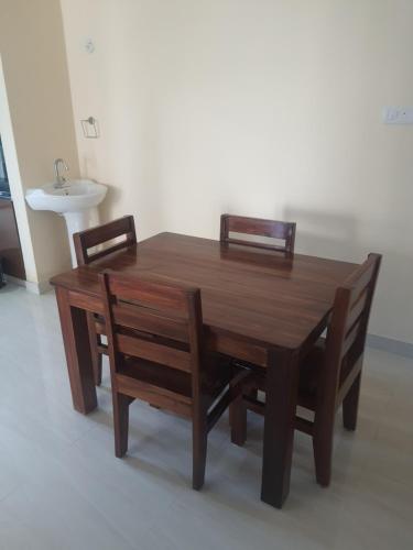 a wooden table with two chairs and a sink at Castle Dollars in Bengaluru