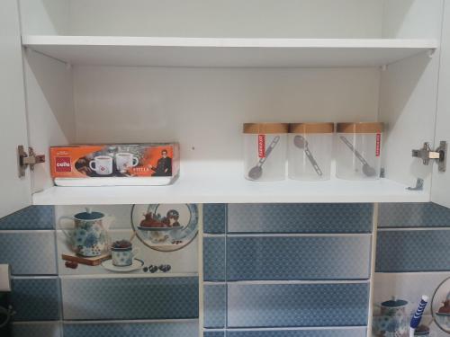 a kitchen cabinet with utensils on a shelf at Castle Dollars in Bangalore