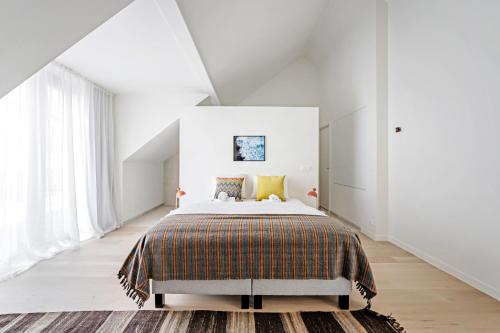 una camera da letto con un grande letto in una stanza bianca di Smartflats - Bell Tower Ghent a Gand