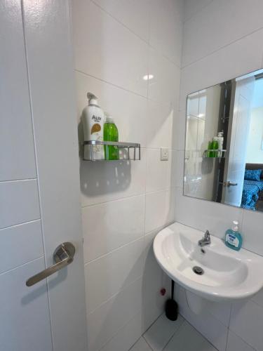 Baño blanco con lavabo y espejo en SNHomestay1826 Sea View @ The Wave Residence en Melaka