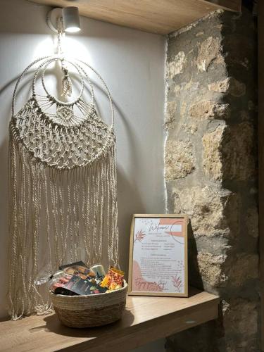 a basket on a wooden table with a chandelier at Casa La Bohema in Afitos