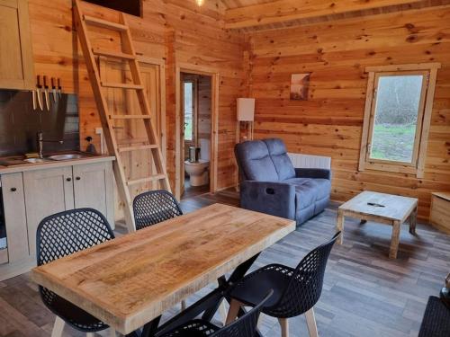 - un salon avec une table et des chaises dans une cabine dans l'établissement Cabane pilotis sur étang, au lac de Chaumeçon, à Saint-Martin-du-Puy