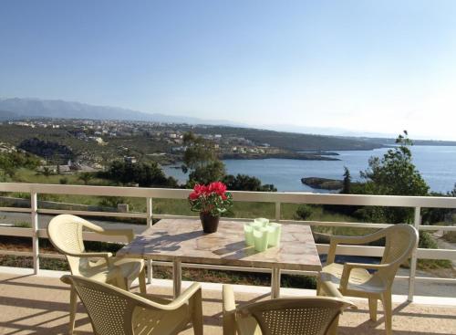 a table and chairs on a balcony with a view of the water at Villas Michalis in Chorafakia