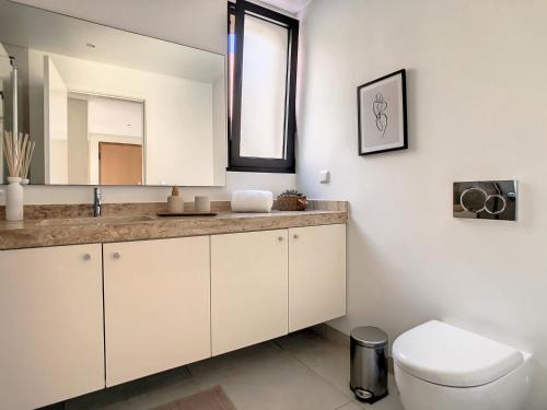 a bathroom with a toilet and a mirror at Sunlight Apartment by LovelyStay in Funchal