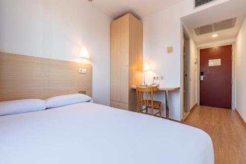 - une chambre avec un lit et une table dans l'établissement Hotel Basic, à Vilafranca del Penedès