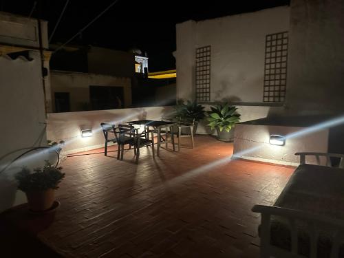 um pátio com uma mesa e cadeiras à noite em Apartment in old town with roof terrace and fibre, Tarifa em Tarifa