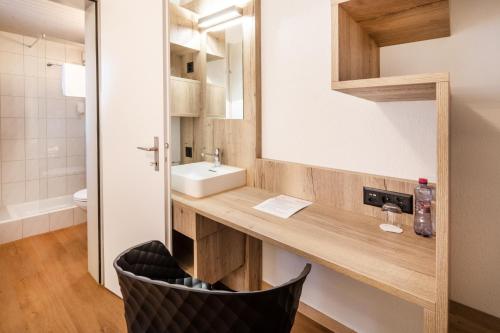 a bathroom with a sink and a mirror at Gasthof Enge Self Check-In Hotel in Solothurn