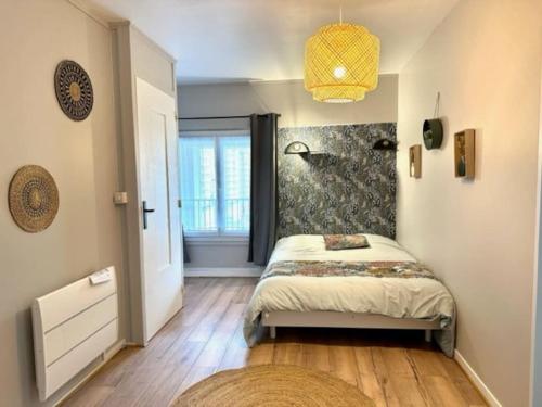 une petite chambre avec un lit et une fenêtre dans l'établissement Le clos notre Dame proche du bord de mer, au Havre