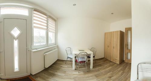 um quarto com uma mesa e cadeiras e uma janela em Helijan Ubytovanie em Nesvady