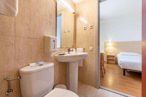 y baño con aseo y lavamanos. en Hotel Basic, en Vilafranca del Penedès