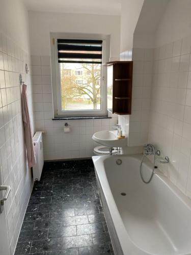 Baño blanco con bañera y lavamanos en Hotel-Sternthaler /Rathauseck, en Müncheberg