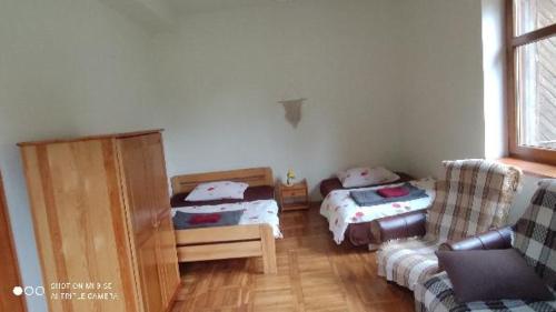 sala de estar con 2 camas y sofá en Osada Włościańska, en Ojców