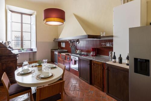 una cocina con mesa y algunas sillas. en Palazzo Roselli Cecconi Apartments, en Florencia