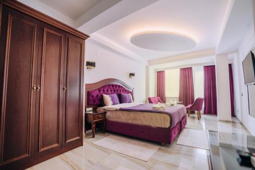 una camera con letto viola e tavolo di Villa Afrodita City Center a Ohrid