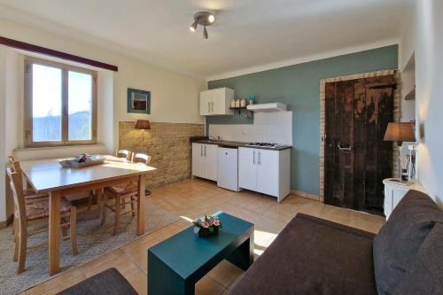 ein Wohnzimmer mit einem Tisch und eine Küche mit einem Sofa in der Unterkunft Villa Pilotti Country House in Penna San Giovanni