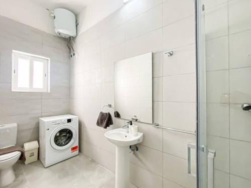 a bathroom with a washing machine next to a sink at 1 Bedroom Penthouse in Gzira in Il-Gżira