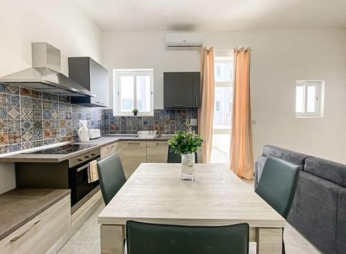 a kitchen and dining room with a table and a couch at 1 Bedroom Penthouse in Gzira in Il-Gżira