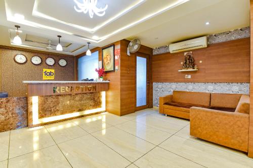 a lobby with a reception desk and a couch at FabHotel Hill Park in Ahmedabad