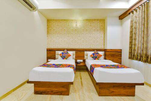 a room with two beds in a room at FabHotel Hill Park in Ahmedabad