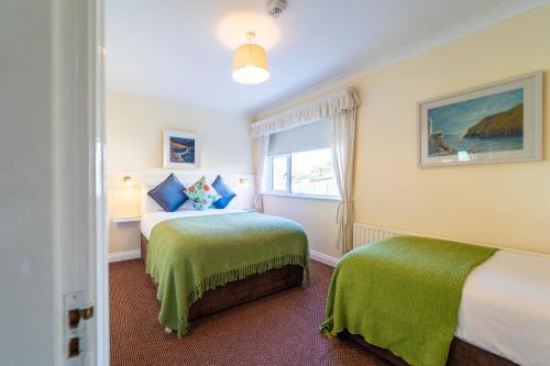 a bedroom with two beds and a window at Ashe's Accommodation - Room only in Dingle
