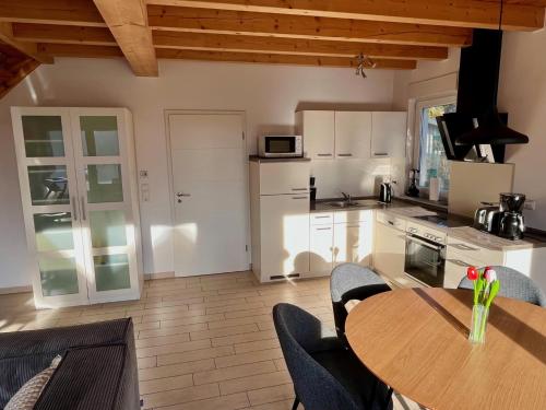 a kitchen with a table and chairs and a kitchen with white cabinets at Meermaid 1 in Plau am See