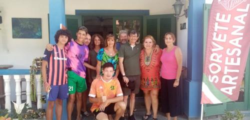 a group of people standing in front of a house at condominio colonial pousada mariscal in Canto Grande
