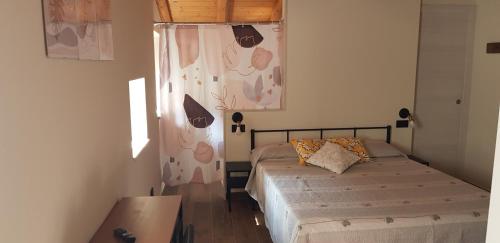 een kleine slaapkamer met 2 bedden en een raam bij CASA NELLI in Caprino Veronese