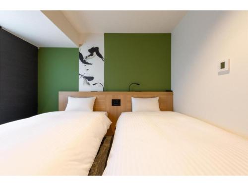 two beds in a room with green walls at The OneFive Kyoto Shijo - Vacation STAY 41807v in Kyoto