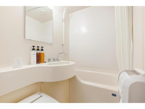 a bathroom with a sink and a toilet and a bath tub at The OneFive Okayama - Vacation STAY 41839v in Okayama