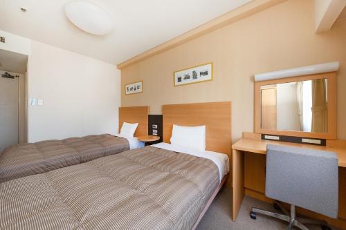 1 Schlafzimmer mit 2 Betten, einem Schreibtisch und einem TV in der Unterkunft The OneFive Okayama - Vacation STAY 41848v in Okayama