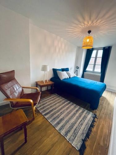 un salon avec un canapé bleu et une chaise dans l'établissement Appartement Petit Messier, à Senones