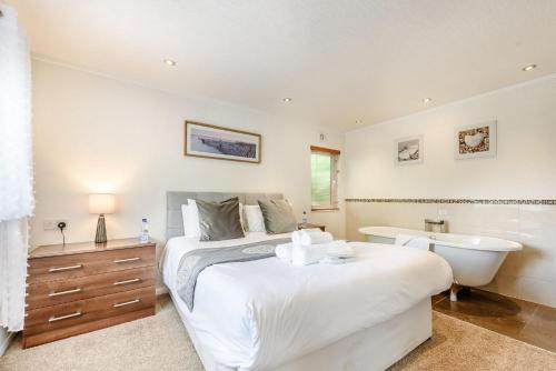 1 dormitorio con cama, bañera y lavamanos en Bay Tree Lodge 02, en Narberth