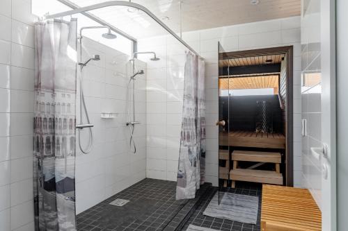 uma casa de banho com um chuveiro e uma porta de vidro em Seaview villa with jacuzzi em Töfsala